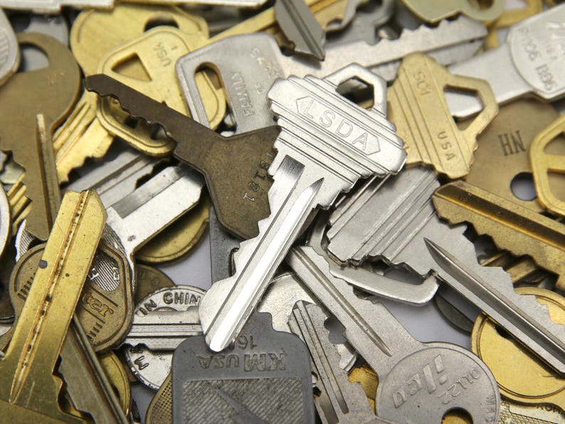 A mix of silver and yellow brass keys. They are in used condition and consist of cut and uncut keys. Types of keys can include, house, file cabinet, padlock, door, car, equipment, and more.  They are great for crafting, and mixed media art projects.