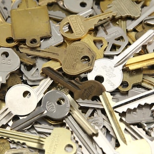 A mix of silver and yellow brass keys. They are in used condition and consist of cut and uncut keys. Types of keys can include, house, file cabinet, padlock, door, car, equipment, and more.  They are great for crafting, and mixed media art projects.