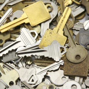 A mix of silver and yellow brass keys. They are in used condition and consist of cut and uncut keys. Types of keys can include, house, file cabinet, padlock, door, car, equipment, and more.  They are great for crafting, and mixed media art projects.
