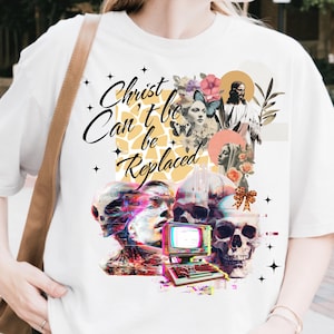 May include: White t-shirt with a graphic design featuring the text "Christ Can't be Replaced". The design includes images of flowers, butterflies, and religious figures, along with skulls and a vintage computer.