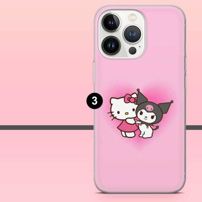 May include: Pink phone case featuring a cartoon image of Hello Kitty and Kuromi hugging, set against a pink heart-shaped background. The case has a clear border and a camera cutout.