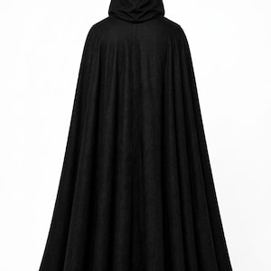 May include: A floor-length black hooded cloak featuring a full, pleated silhouette that drapes from the shoulders to the hem. The garment is constructed from a solid black fabric and includes an attached hood that rests at the top of the back.