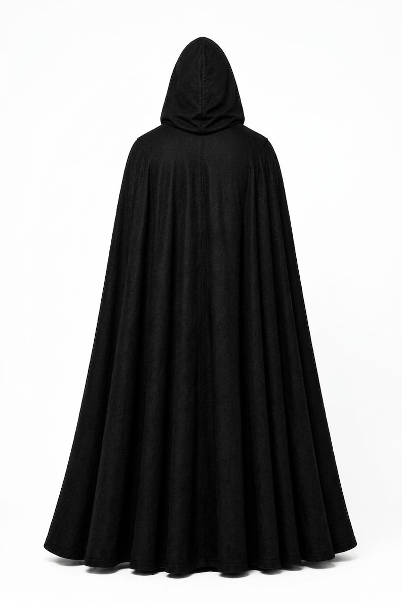 May include: A floor-length black hooded cloak featuring a full, pleated silhouette that drapes from the shoulders to the hem. The garment is constructed from a solid black fabric and includes an attached hood that rests at the top of the back.