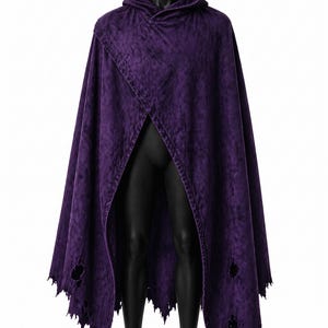 May include: A deep purple hooded cloak with a distressed, textured appearance. The cloak features a split front design and jagged edges along the bottom. The cloak is displayed on a black mannequin.