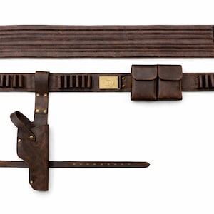 May include: A brown leather gun belt with a holster, cartridge holders, and two pouches. The belt includes a separate band for the back and a smaller belt with a buckle. The leather has a distressed appearance.