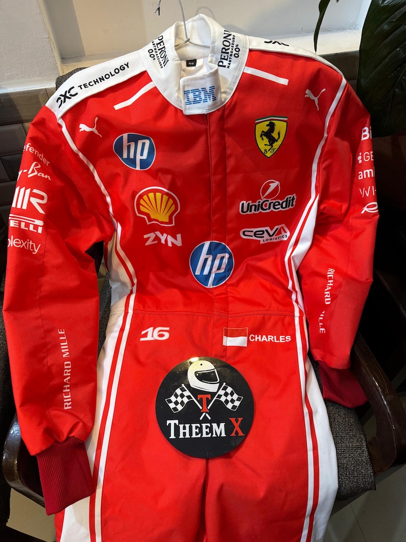 May include: A red and white racing suit with various sponsor logos, including "HP," "Shell," and "Unicredit." The Ferrari logo, the number "16," and the name "CHARLES" are displayed. The text "THEEM X" is also visible.