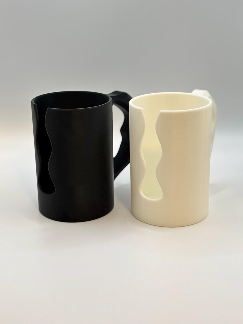 May include: A set of three ceramic mugs with a speckled, matte finish. The mugs are in shades of cream, light gray, and dark gray. Each mug has a simple, minimalist design, perfect for coffee or tea.