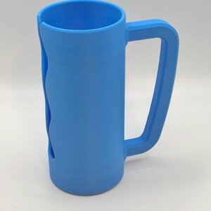 May include: A light blue, 3D-printed mug with a large handle and a unique wave-like cutout on the side. The mug is cylindrical with a flat bottom and a wide opening. The handle is rectangular and attached to the side of the mug.