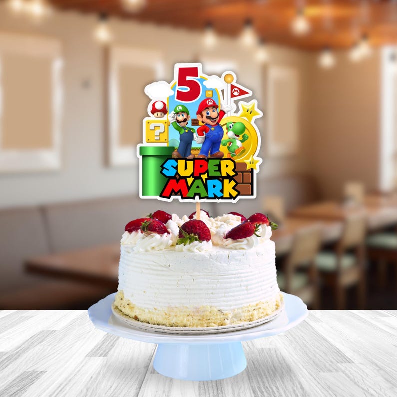K&ouml;nnte beinhalten: Ein runder, wei&szlig; glasierter Kuchen, garniert mit frischen Erdbeeren und einem Tortenstecker im Super Mario-Design mit der Zahl 5, Mario, Luigi, Yoshi, einem gr&uuml;nen Rohr, einem Fragezeichenblock und dem Text SUPER MARK auf hellblauem Grund.