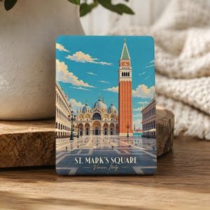 May include: A rectangular magnet featuring a colorful illustration of St. Mark's Square in Venice, Italy. The image displays the iconic bell tower, the basilica, and the open plaza under a blue sky. The text reads St. Mark's Square Venice, Italy.