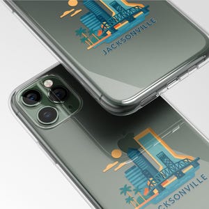May include: Two clear phone cases with a Jacksonville, Florida design. The design features a bridge, buildings, palm trees, and the word "JACKSONVILLE" in blue and orange. The cases are on a white background.