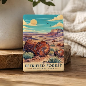 May include: A rectangular magnet featuring a landscape of the Petrified Forest National Park in Arizona. The artwork depicts a desert scene with a large petrified log in the foreground, a mesa, and a blue sky with a sun and clouds. The text "Petrified Forest National Park Arizona" is at the bottom.