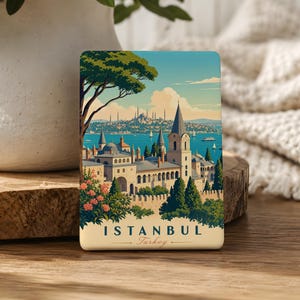 May include: A rectangular magnet featuring a colorful illustration of Istanbul, Turkey. The artwork depicts a coastal city with buildings, trees, and a body of water. The text "ISTANBUL Turkey" is at the bottom of the magnet.