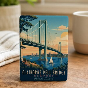 May include: A rectangular magnet featuring a stylized illustration of the Claiborne Pell Bridge in Newport, Rhode Island. The artwork depicts the suspension bridge over blue water with a sailboat, orange sunset sky, and foliage. Text reads: CLAIBORNE PELL BRIDGE NEWPORT Rhode Island.