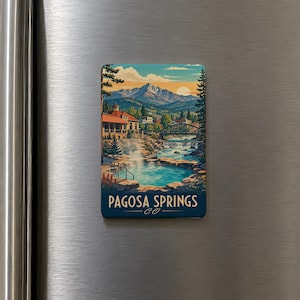 May include: A rectangular magnet featuring a scenic illustration of Pagosa Springs, CO. The artwork depicts a mountain range, a river, a bridge, and a building with a red roof. The text "Pagosa Springs CO" is displayed at the bottom.