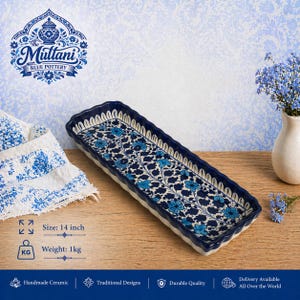 May include: A rectangular ceramic serving dish with a blue floral design. The dish is 14 inches long and weighs 1 kg. It has a scalloped edge and is decorated with a repeating pattern of blue flowers and vines. The words "The Multani Blue Pottery" are in the image.