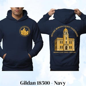 May include: A navy blue hooded sweatshirt featuring a gold circular logo on the front chest that reads Town of Berkeley Springs 1776. The back displays a yellow illustration of the Historic Morgan County Courthouse with the text Original Clock Tower Circa 1907.