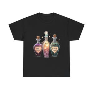 May include: Black t-shirt featuring three potion bottles with cork stoppers. The bottles are labeled "Love Potions" and "Healing Elixirs." The center bottle has a sun design. The bottles are in shades of purple, yellow, and green.