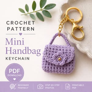 Könnte beinhalten: Ein Häkelmuster für einen Mini-Handtaschen-Schlüsselanhänger. Die lavendelfarbene Handtasche hat ein Blumendetail und einen goldfarbenen Verschluss. Der Text auf dem Bild lautet "CROCHET PATTERN Mini Handbag KEYCHAIN PDF DOWNLOAD".