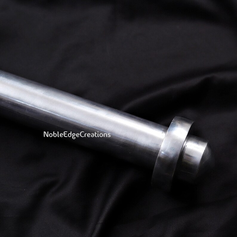 May include: A close-up of a silver metal rod with a rounded end and a circular ring. The rod is set against a black background. The text "NobleEdgeCreations" is visible on the image.