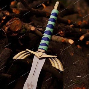 May include: A fantasy sword with a silver blade and gold accents. The hilt is wrapped in blue and green fabric. The sword is set against a backdrop of dark brown wooden logs.