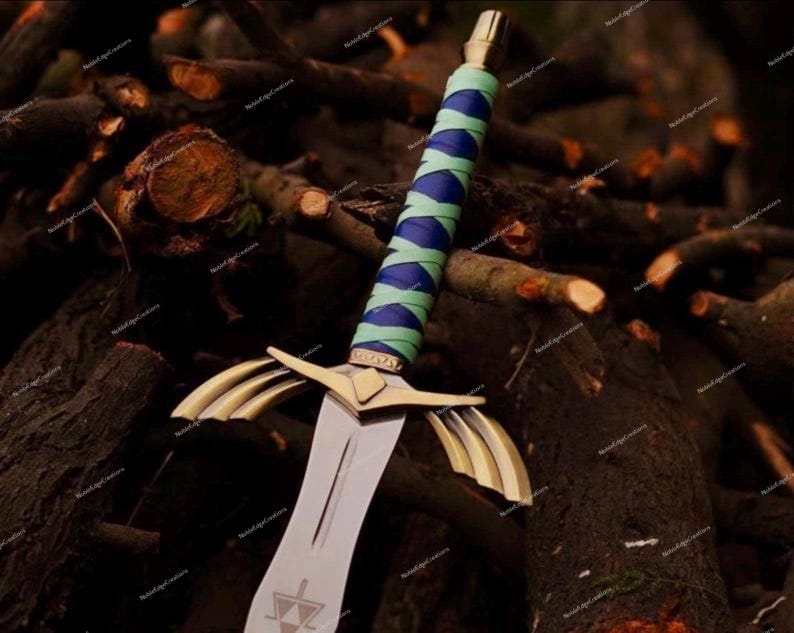 May include: A fantasy sword with a silver blade and gold accents. The hilt is wrapped in blue and green fabric. The sword is set against a backdrop of dark brown wooden logs.