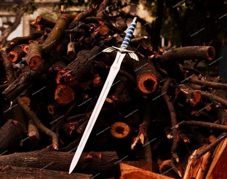 May include: A silver sword with a blue and white handle rests on a pile of brown logs. The sword has a detailed hilt and a long, sharp blade. The logs are cut and stacked, creating a rustic backdrop.