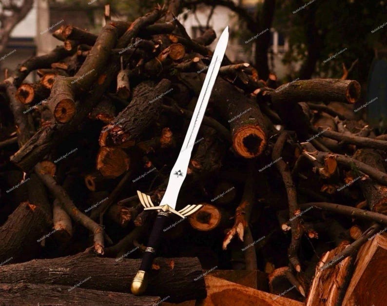 May include: A decorative sword with a silver blade and a black handle. The sword features gold accents on the hilt and a gold pommel. The sword is displayed against a backdrop of stacked logs.