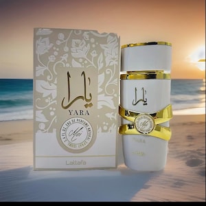 Puede incluir: Un frasco de perfume blanco con detalles dorados y la palabra "YARA" en escritura dorada, junto a una caja a juego. La caja presenta el mismo texto y dise&ntilde;os florales. El frasco contiene 100 ml de perfume.