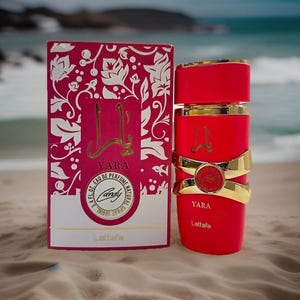 Puede incluir: Un frasco de perfume rojo con detalles dorados y una caja a juego. La caja es rosa con un dise&ntilde;o floral blanco y la palabra "Yara" en dorado. El frasco es cil&iacute;ndrico con bandas doradas y el nombre "Yara" en dorado.