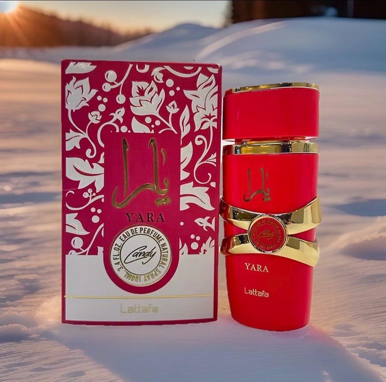Puede incluir: Un conjunto de perfume rojo con detalles dorados. El frasco tiene una banda dorada y la caja presenta un dise&ntilde;o floral. Los textos "YARA" y "Candy" son visibles. El perfume es de 100 ml.