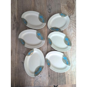 May include: A white ceramic mug with a black handle and the text "But First, Coffee" in a bold, black font. The mug is set against a neutral background, highlighting its simple design.