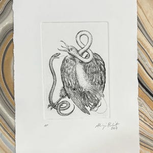May include: A monochrome etching print showing a bird with a snake coiled around its neck and another snake facing it. The artwork is signed "Aliya Pulit 2019" and numbered "4/5". The print is on textured white paper.