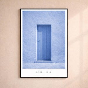 May include: Framed art print featuring a blue door set in a textured blue wall. The door has a simple handle and is centered in the frame. The text "DOOR - BLUE" is printed at the bottom of the image.