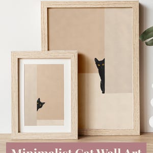 Puede incluir: Dos impresiones enmarcadas con arte minimalista de gatos. La obra de arte representa gatos negros asomándose por las esquinas sobre un fondo beige y crema neutro. Los marcos son de madera clara. El texto en la parte superior dice "NEUTRAL AESTHETIC DECOR" y en la parte inferior "MINIMALIST CAT WALL ART".