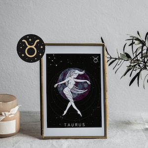 Puede incluir: Impresión artística enmarcada del signo zodiacal Tauro. La obra de arte representa a una mujer con cabello suelto sobre un fondo celestial. La impresión está en un marco dorado, con un emblema circular negro y dorado.