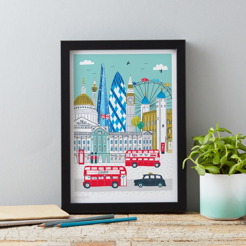 May include: A framed print of a colorful illustration of London landmarks, including Big Ben, the London Eye, and red double-decker buses. The print has a blue and green background and the text "London" is visible.