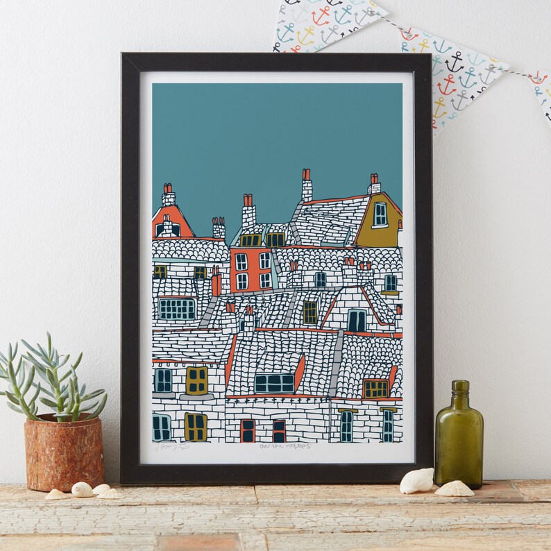 Puede incluir: Una ilustraci&oacute;n enmarcada de una fila de casas con techos y ventanas de colores sobre un fondo azul verdoso. La ilustraci&oacute;n se titula "The Old Town Roofs".