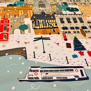 May include: A festive illustration of a snowy cityscape with a river and a boat. The scene features a church, buildings, a Christmas tree, and a signpost. The boat is labeled "York" and has a red life ring. The illustration is in a cartoon style with bright colors.