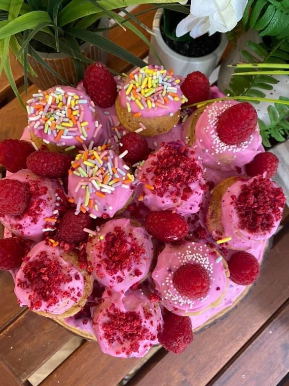 Vegan special edition vanilla pink raspberry cake with mini donuts,  fresh raspberries and rainbow sprinkles    8”!