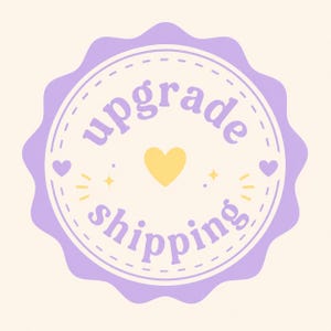 May include: A light purple badge with the words "upgrade shipping" in a circular design. The badge has a scalloped edge and features a yellow heart and starburst accents. The background is a soft cream color.