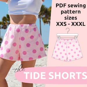 May include: Light pink shorts with a darker pink polka dot pattern. The image includes text reading PDF sewing pattern sizes XXS - XXXL and the TIDE SHORTS. A line drawing of the shorts on a hanger is shown on a light pink background.