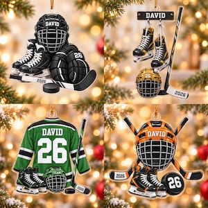 May include: A collection of four flat acrylic hockey-themed ornaments. Each features a personalized name tag reading DAVID, the number 26, and the year 2026. The designs include hockey helmets, skates, sticks, jerseys, and pucks in various colors.