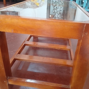 Puede incluir: Una taza de cerámica blanca con un asa negra y el texto "But First, Coffee" en negro y negrita. La taza está sobre una superficie blanca. La taza mide 10 cm de alto.