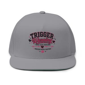 Könnte beinhalten: Graue Cap mit flachem Schirm und dem Text "TRIGGER WARNING" in Rosa und Schwarz. Der Text "I READ DARK ROMANCE" und "PROCEED WITH CAUTION" ist ebenfalls zu sehen. Die Unterseite des Schirms ist grün.