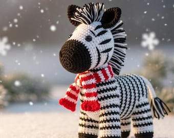 May include: A crocheted zebra figurine with black and white stripes, black ears, and a red and white striped scarf. The handmade animal is standing in the snow, with snowflakes falling in the background. The zebra has a black mane and tail.