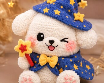 Puede incluir: Un juguete de peluche de perro blanco con un sombrero y capa de mago azul decorados con estrellas amarillas. El perro tiene mejillas rosadas, una pajarita amarilla y sostiene una varita con punta de estrella. Sus patas tienen almohadillas rosadas y guiña un ojo.