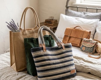 May include: A collection of bags including a large tan jute tote with lavender sprigs, a dark green canvas tote, a striped woven tote with leather handles, a tan leather satchel, and a small patterned crossbody bag with a long strap.