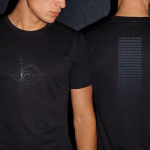May include: A black short-sleeved t-shirt featuring a white geometric spiral graphic on the front chest and a rectangular block of small white numerical text printed on the back, showcasing a grid of numbers arranged in multiple rows and columns.