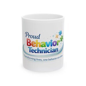May include: White ceramic mug with the text "Proud Behavior Technician" in colorful lettering. The mug also features puzzle piece graphics and the phrase "Transforming lives, one behavior at a time."